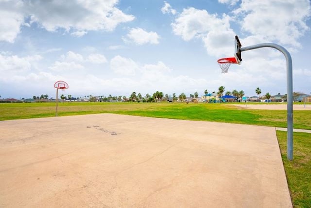 view of sport court featuring a lawn