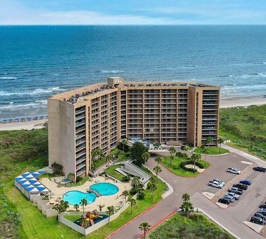 drone / aerial view featuring a water view and a view of the beach