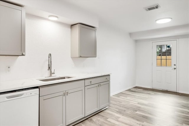 2108 Matagorda Dr, Portland, TX 78374 - kitchen featuring white dishwasher, gray cabinetry, light wood finished floors, and light stone counters