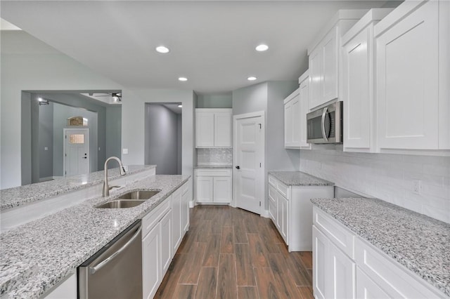407 Main, Odem, TX 78370 - kitchen featuring appliances with stainless steel finishes, light stone countertops, backsplash, a ceiling fan, and white cabinets