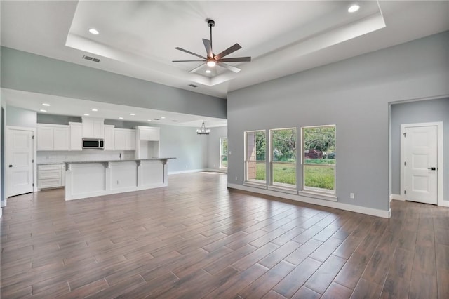 407 Main, Odem, TX 78370 - unfurnished living room with a raised ceiling, a ceiling fan, a towering ceiling, recessed lighting, and a chandelier