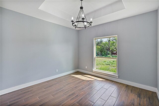 407 Main, Odem, TX 78370 - spare room with a raised ceiling, a chandelier, and wood finished floors
