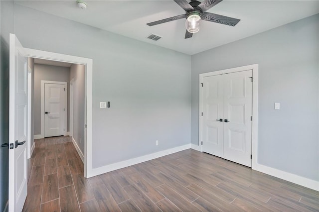 407 Main, Odem, TX 78370 - unfurnished bedroom with dark wood-style floors, a closet, and a ceiling fan