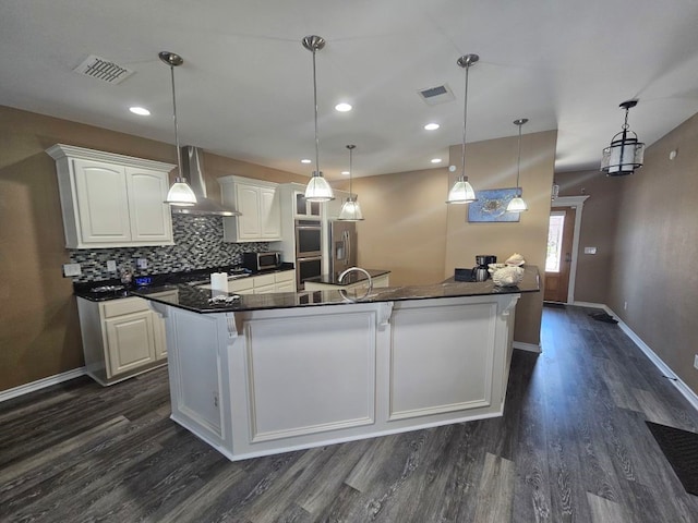 15333 Beaufort Ct, Corpus Christi, TX 78418 - kitchen featuring wall chimney range hood, dark countertops, dark wood finished floors, backsplash, and recessed lighting