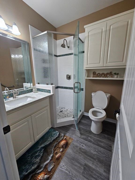 15333 Beaufort Ct, Corpus Christi, TX 78418 - bathroom featuring a stall shower, vanity, and wood finished floors