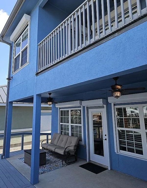 15333 Beaufort Ct, Corpus Christi, TX 78418 - property entrance featuring ceiling fan, stucco siding, and a patio area