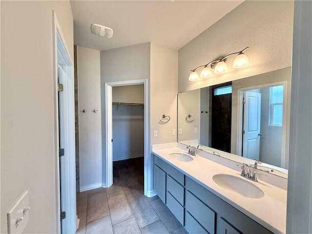 1030 Ocean Breeze St, Portland, TX 78374 - bathroom featuring tile patterned flooring, double vanity, and a walk in closet