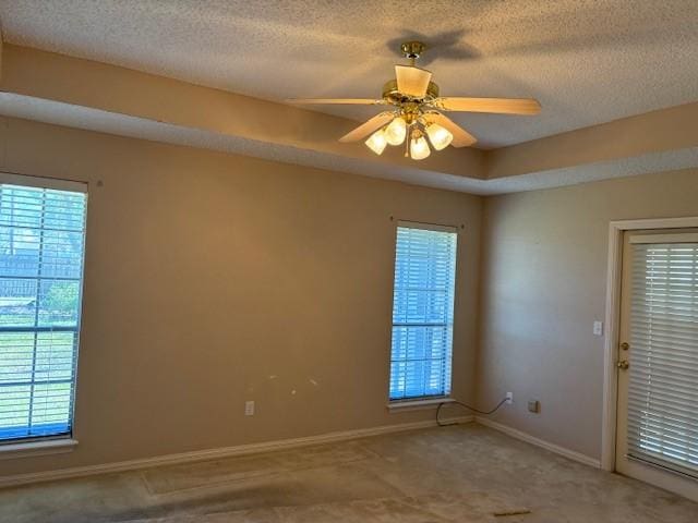 spare room featuring ceiling fan, a textured ceiling, and a wealth of natural light