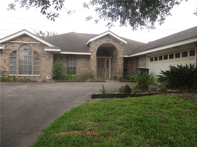 ranch-style home featuring a front yard and a garage