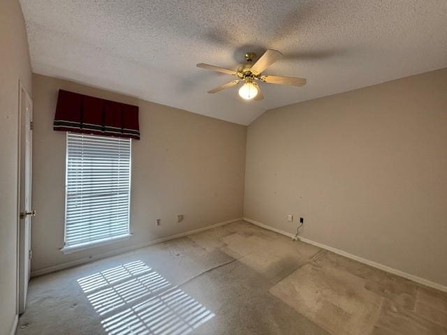 unfurnished room with a textured ceiling, ceiling fan, and vaulted ceiling