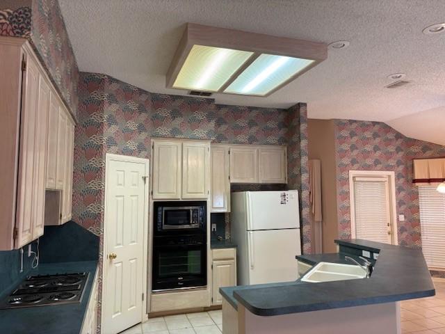 kitchen with built in microwave, sink, white fridge, oven, and stainless steel gas stovetop