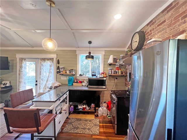 kitchen with french doors, stainless steel appliances, dark hardwood / wood-style floors, pendant lighting, and wooden walls