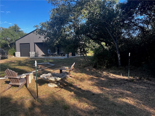 view of yard featuring a garage and an outdoor structure