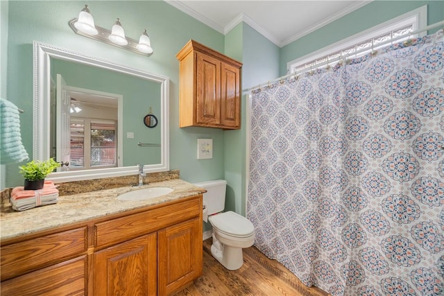 bathroom featuring toilet, ornamental molding, wood finished floors, and vanity