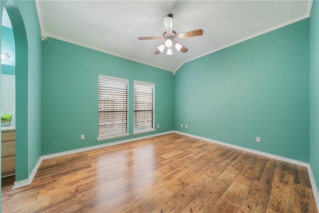 spare room with ornamental molding, a ceiling fan, baseboards, and wood finished floors