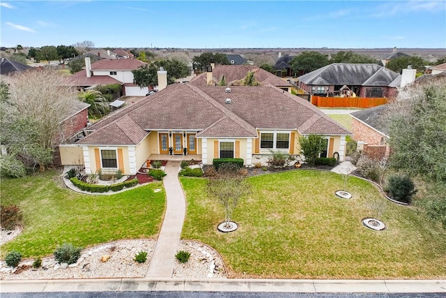 view of front of house featuring a shingled roof, a residential view, and a front yard