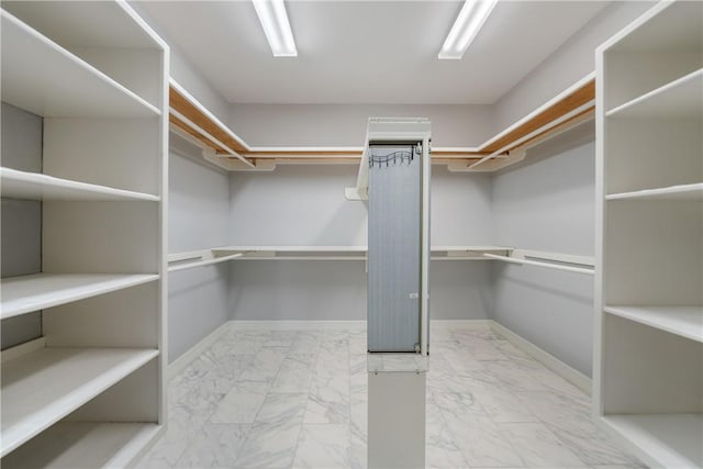 spacious closet featuring marble finish floor