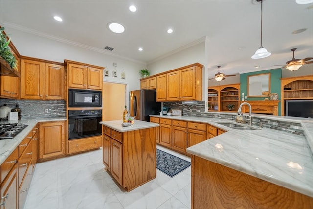 kitchen with a sink, a kitchen island, visible vents, black appliances, and decorative light fixtures