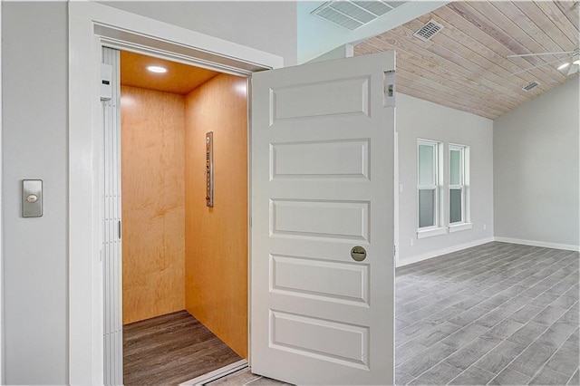 interior space featuring hardwood / wood-style floors, wooden ceiling, and elevator