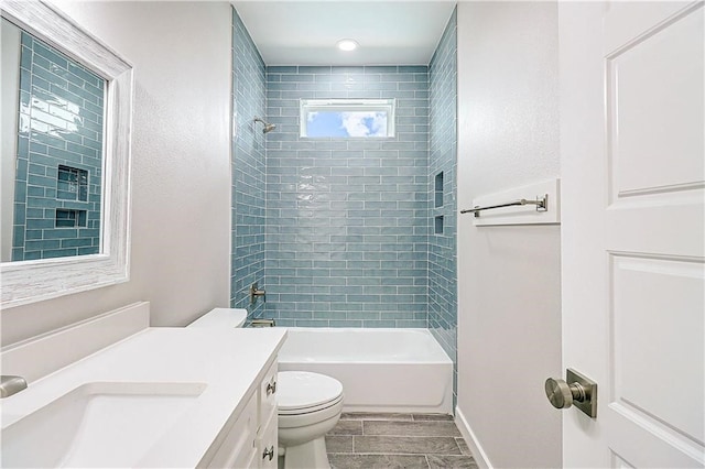 full bathroom featuring vanity, plenty of natural light, toilet, and tiled shower / bath combo