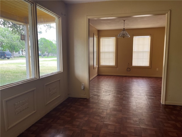 unfurnished dining area with a wealth of natural light and dark parquet floors