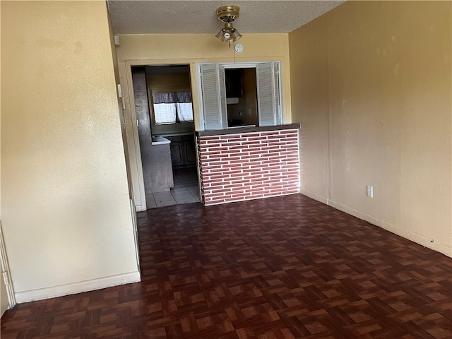 unfurnished room featuring dark parquet floors and a textured ceiling