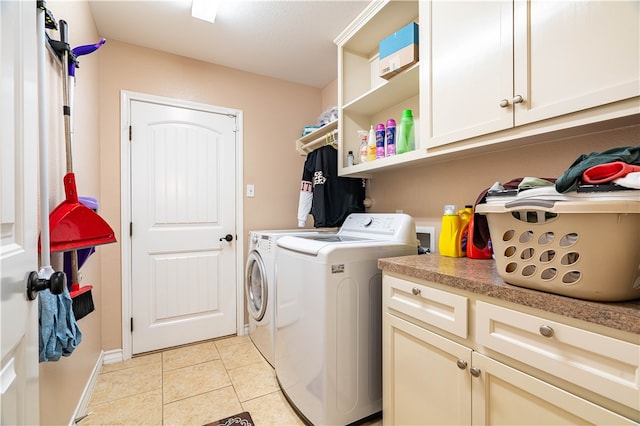 washroom with washing machine and dryer, cabinets, and light tile patterned floors