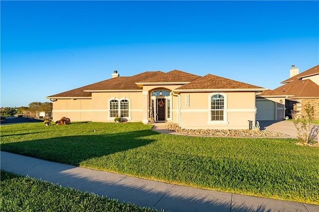 mediterranean / spanish house with a garage and a front lawn