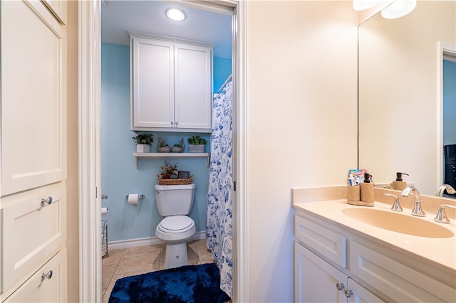 bathroom with toilet, vanity, and tile patterned floors