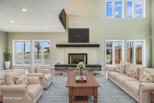 living area featuring recessed lighting, a fireplace with raised hearth, and baseboards