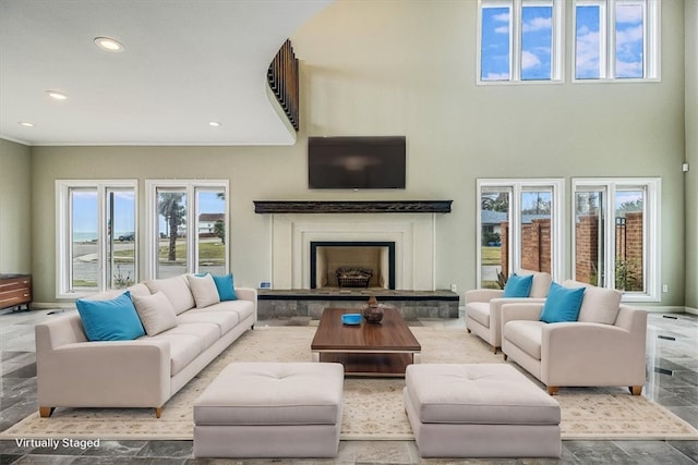 living room with recessed lighting, a healthy amount of sunlight, and a fireplace with raised hearth