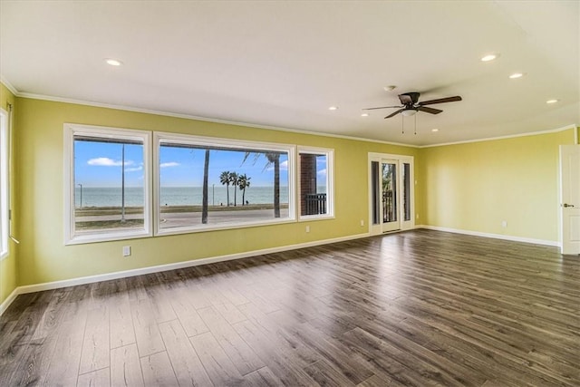 unfurnished room with recessed lighting, crown molding, dark wood-type flooring, and baseboards