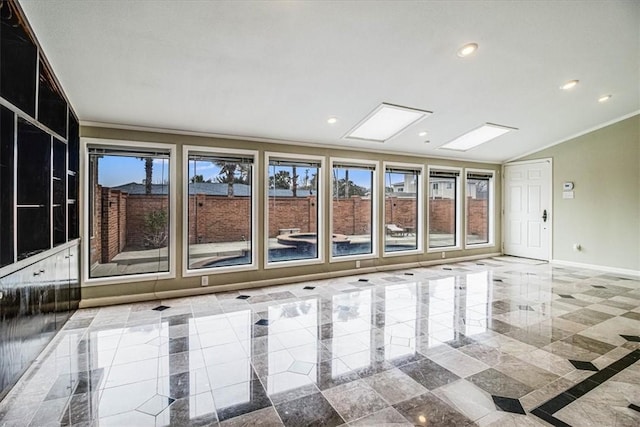 spare room with recessed lighting, baseboards, ornamental molding, and vaulted ceiling with skylight