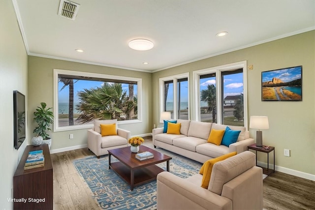 living area featuring visible vents, crown molding, baseboards, and wood finished floors