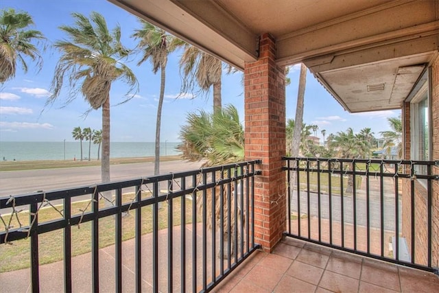 balcony with a water view and a view of the beach