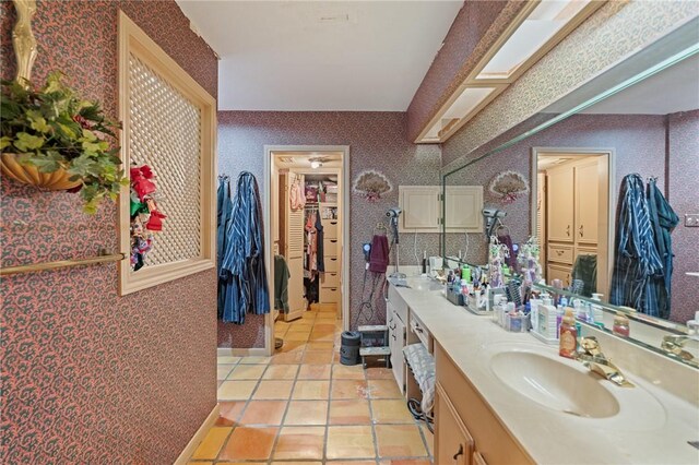 7033 Chiswick Dr, Corpus Christi, TX 78413 - full bath with wallpapered walls, double vanity, tile patterned floors, and a walk in closet