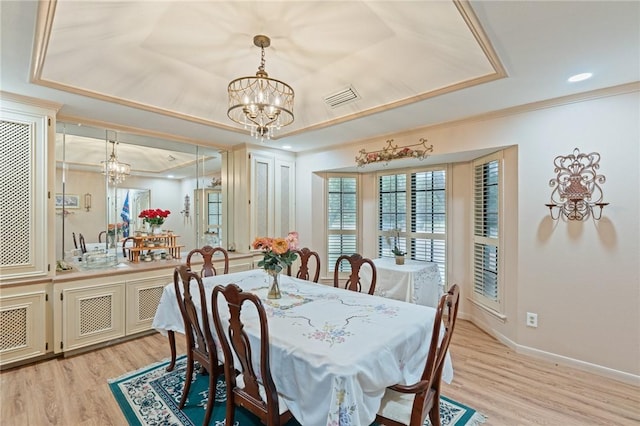 7033 Chiswick Dr, Corpus Christi, TX 78413 - dining space with a raised ceiling, a chandelier, light wood finished floors, and ornamental molding