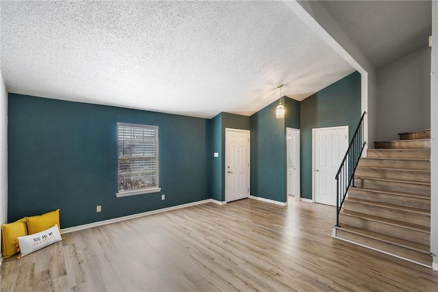 interior space with lofted ceiling, light hardwood / wood-style floors, and a textured ceiling