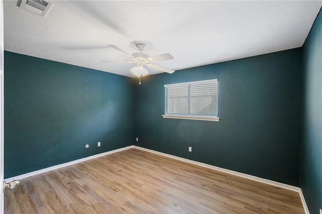 spare room featuring ceiling fan, light hardwood / wood-style flooring, and a textured ceiling