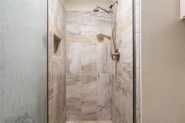 interior details featuring tiled shower