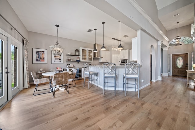 kitchen with light hardwood / wood-style flooring, decorative light fixtures, a healthy amount of sunlight, and white cabinets