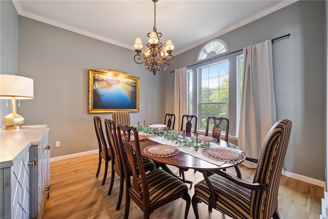 dining area featuring light hardwood / wood-style flooring, a chandelier, and crown molding