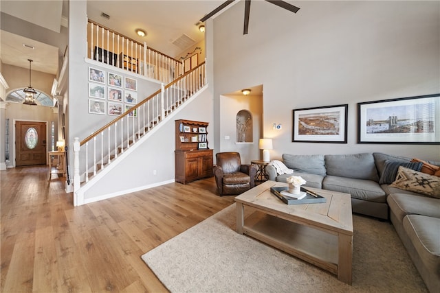 living room featuring a high ceiling, hardwood / wood-style flooring, and ceiling fan