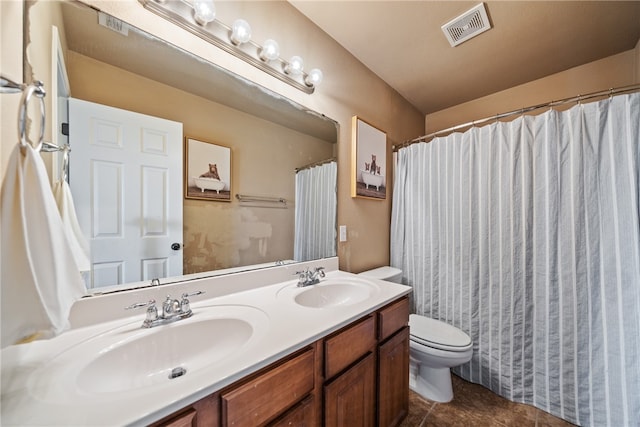 bathroom featuring vanity, tile patterned floors, and toilet