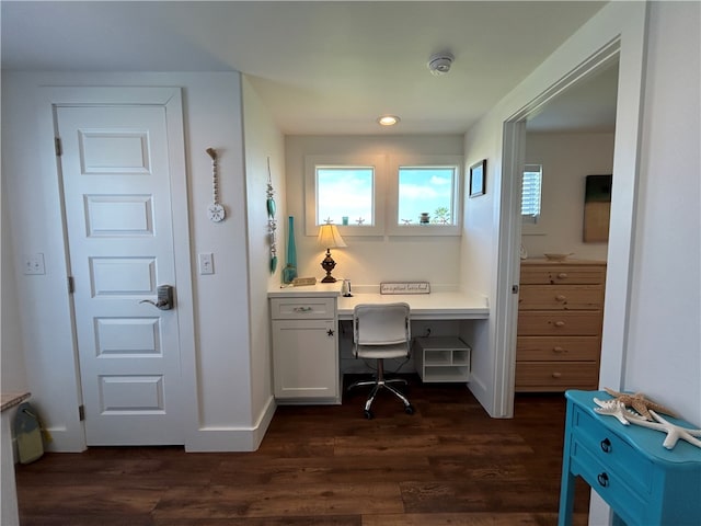 office space featuring dark hardwood / wood-style flooring and built in desk