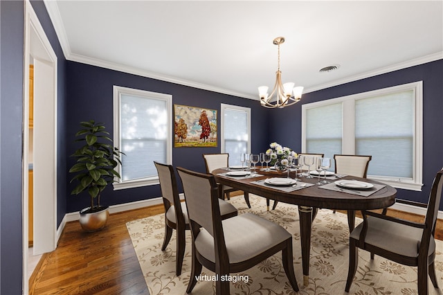 dining area featuring dark wood-type flooring, crown molding, and a notable chandelier