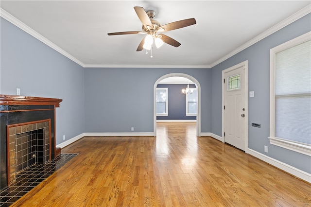 unfurnished living room featuring a fireplace, ceiling fan, light hardwood / wood-style flooring, and crown molding