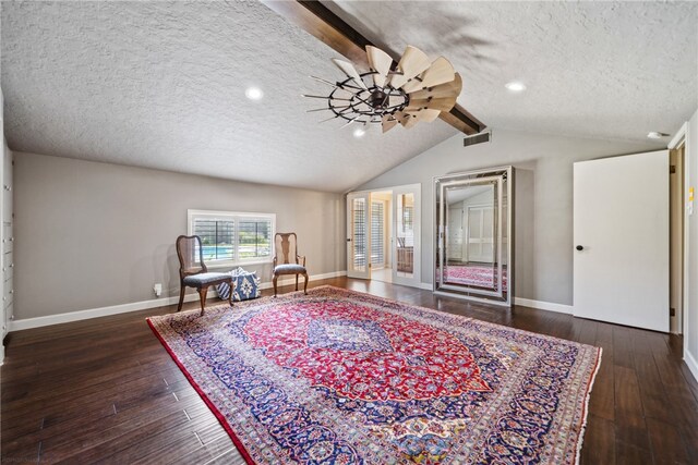 sitting room with lofted ceiling with beams, ceiling fan, dark wood-type flooring, and a textured ceiling