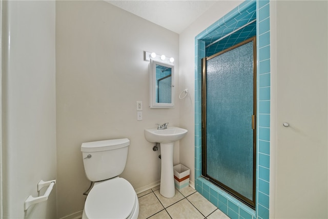 bathroom featuring tile patterned flooring, toilet, walk in shower, and sink