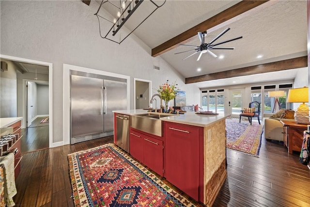 kitchen with a kitchen island with sink, sink, ceiling fan, dark hardwood / wood-style floors, and appliances with stainless steel finishes